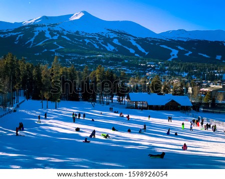 Kids sledding at Carter Park on a snowy hill in Breckenridge, Colorado.