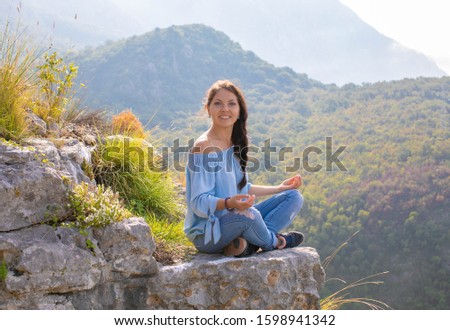 The girl practices yoga and meditation in the mountains at dawn. Mountains of Montenegro. Picture