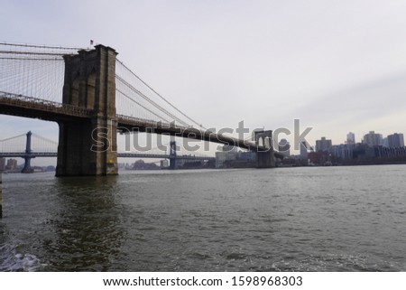 Brooklyn Bridge under the sun calm water winter