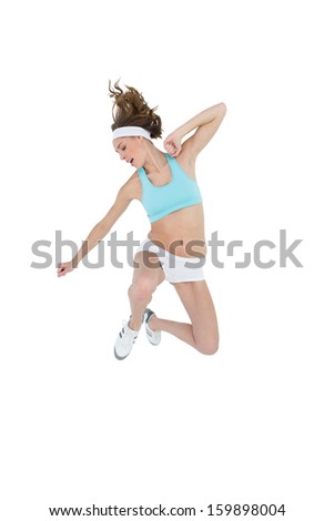 Sporty slender woman wearing sportswear jumping on white background