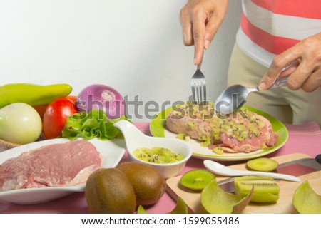 A housewife is marinating beef with kiwi fruit, kitchen tips for make meat tender