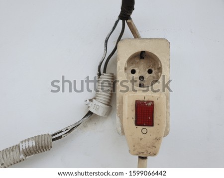A cable and a socket are mounted on the wall