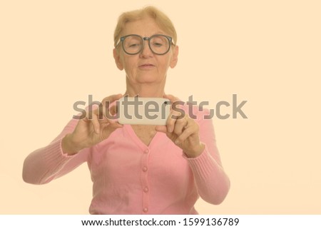 Senior nerd woman taking picture with mobile phone