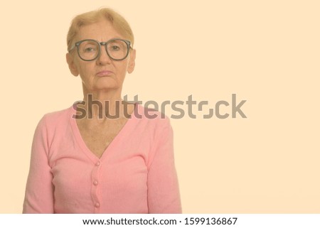 Studio shot of senior nerd woman wearing geeky eyeglasses