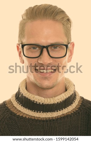 Face of happy young handsome man smiling while wearing eyeglasses