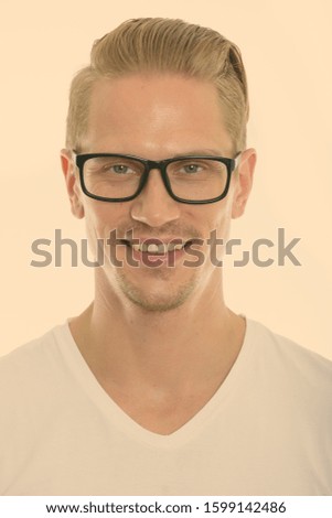 Face of happy young handsome man smiling while wearing eyeglasses
