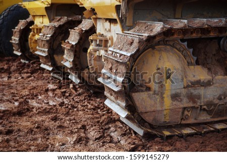 The dirty dozer crawler undercarriage is covered in clay.  Royalty-Free Stock Photo #1599145279