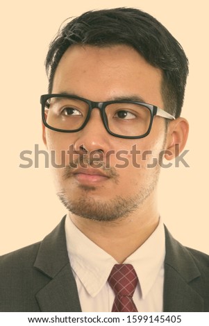 Face of young Asian businessman thinking while wearing eyeglasses