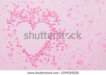 Pink Valentines Day heart frame out of sequin with paint spatter on a pastel pink background