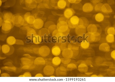 Defocused of blurred golden bokeh circle light from lighting bulb Merry Christmas 
 and Happy New Year decorative in the night for abstract background texture