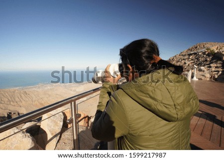 A man looking through high powered binoculars.