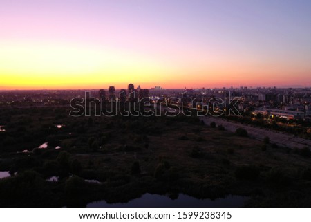 Bucharest drone view at sunset, at Delta Vacaresti, with modern buildings silhouettes, and the river Dambovita.