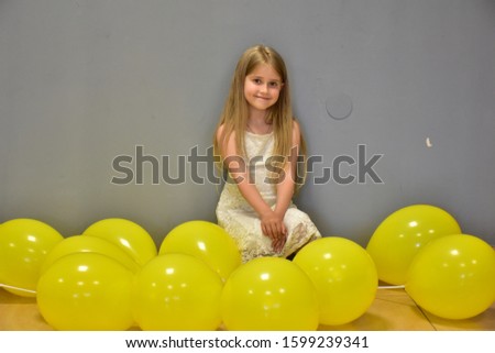little girl with yellow balls