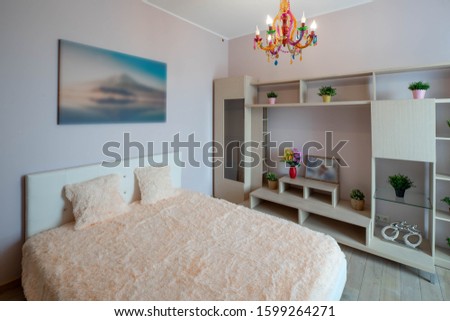 View of king-size bed. Modern interior of bedroom in light tones.