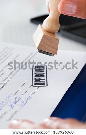 Close-up Of Business Man Hand Pressing Rubber Stamp On Document Royalty-Free Stock Photo #159926960