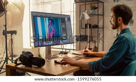 Professional Photographer Sitting at His Desk Uses Desktop Computer in a Photo Studio Retouches. After Photoshoot He Retouches Photographs of Beautiful Female Model in an Image Editing Software