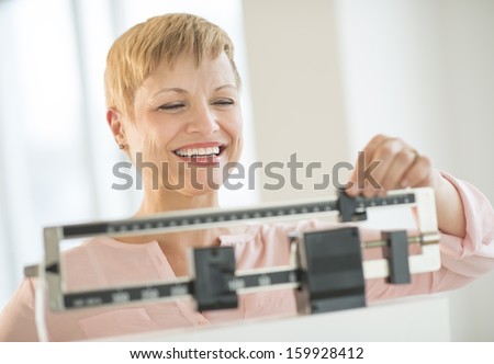 Woman adjusting sliding weight scale Royalty-Free Stock Photo #159928412