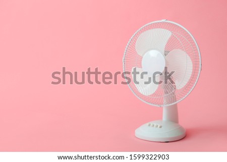 Electric fan on color background