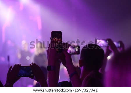 people is taking picture during the concert
