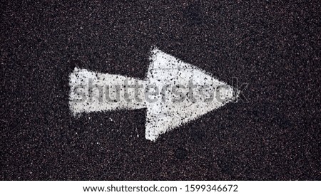 white arrow painted on asphalt