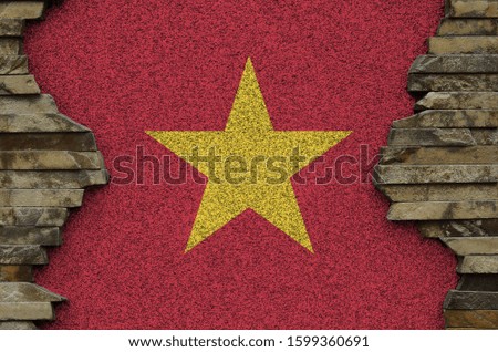 Vietnam flag depicted in paint colors on old stone wall closeup. Textured banner on rock wall background
