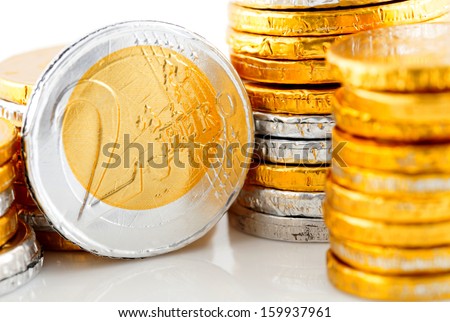 pile of chocolate Euro money in closeup over white background