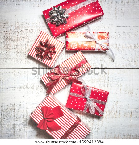 Christmas greeting card with different gift boxes on white wooden background. Top view with copy space.
