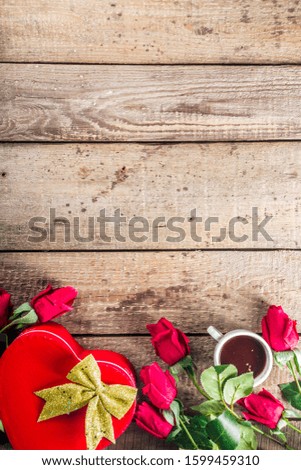 Valentine's day congratulations concept. Background for congratulation cards. Roses, valentine gift box with bow, cup of hot chocolate or coffee, notepad. On a wooden background, top view copy space