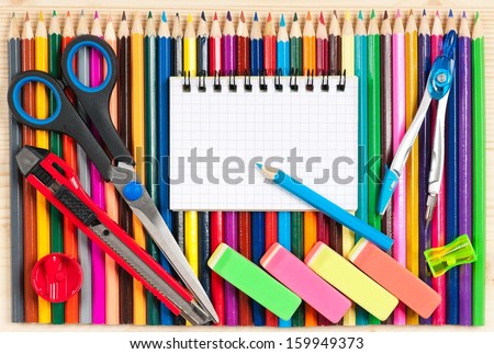 Color pencils with school accessories over wooden surface