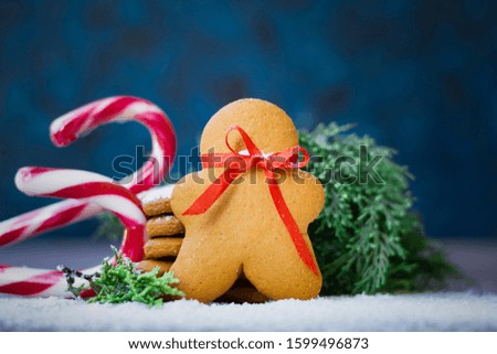 Gingerbread in the form of a man on a blue background; a Christmas card with a copy space; Christmas sweets; greeting happy new year and Christmas.