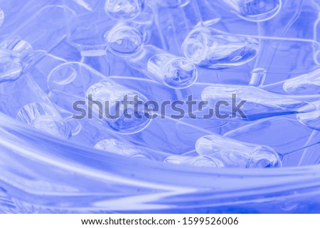 Glass medical ampoule vial for injection. Medicine is liquid sodium chloride with of aqueous solution in ampulla. Close up. Bottles ampule multicolor on background color and water. Human plasma. Royalty-Free Stock Photo #1599526006