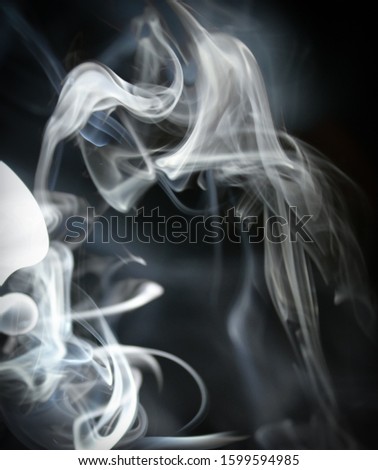 Blue tinted twirling smoke pattern in front of a black background with a slight vignette border/drifting smoke overlay or texture design.