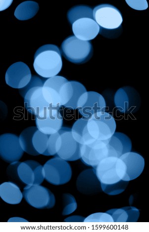 Black background with classic blue  bokeh lights. Holiday, Christmas and New Year background. Horizontal, perfect for layering