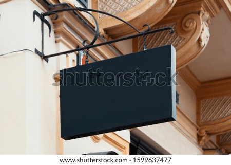 Blank Antique Black Store Signboard Mock up. Empty Shop Signage Template Mounted on Ancient Wall in European Town
