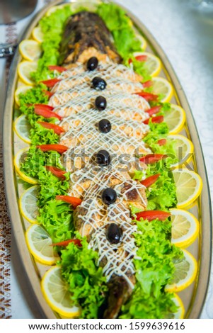 stuffed pike decorated with slices of lemon and butter cream