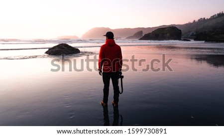 A landscape photographer soaks in the sunset on the Oregon Coast