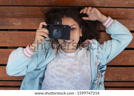 
Young woman photographer in the park photographing with her old reflex camera