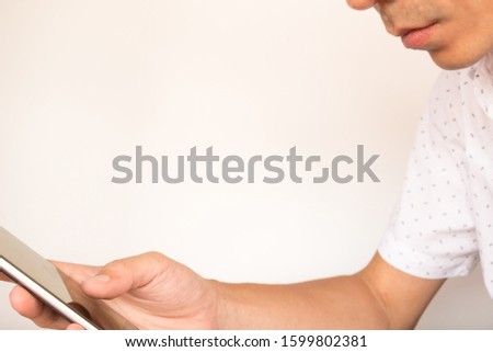 a man is sitting on chair and use smart phone with right hand.