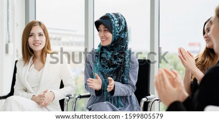 Asian business women group And a Muslim friend sitting in a meeting room Everyone is applauding the success work of team. Give acceptance and reliability to each other The concept of women's rights 