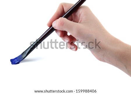 Hand holding brush with blue paint isolated on white