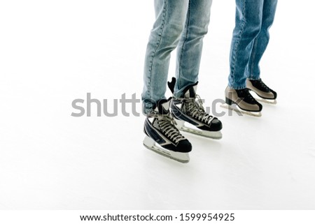 cropped view of young couple in skates skating on rink