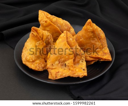 Indian Street Food Samosa or Samosas is a Crispy And Spicy Triangle Shape Snack Which Has Crisp Outer Layer of Maida & Filling of Mashed Potato, Peas And Spices. Served With Chutney, Ketchup or Curd Royalty-Free Stock Photo #1599982261