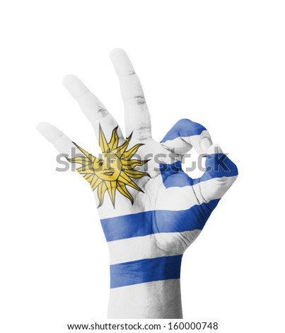 Hand making Ok sign, Uruguay flag painted as symbol of best quality, positivity and success - isolated on white background