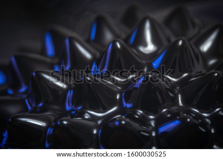 a close up abstract macro photo of iron based ferrofluid spikes with a shallow depth of field and lit by a blue flash gel