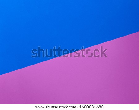 Two trendy colored papers arranged in diagonal top view. Pink and blue paper texture abstract background with copy space for your design. Can be used for greeting cards, banners.