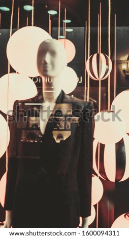 A mannequin stands in the window of a clothing store. Clothing store concept - mannequins in a display window