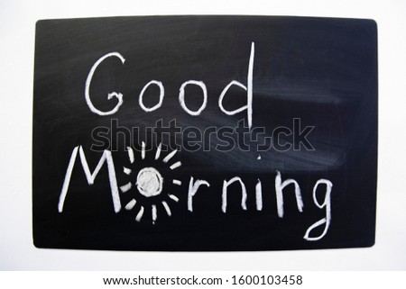 GOOD MORNING phrase on black background by chalk. Handwritten illustration on chalkboard. Child drawing.  