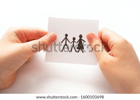 Child holds a picture of a family. Close up.