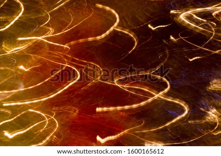 Effect of slow shutter speed of camera. Glowing and lightening of stars and fireworks. Colorful trendy background. Futuristic backdrop with flashes of lights. Festive abstract texture. Selective focus