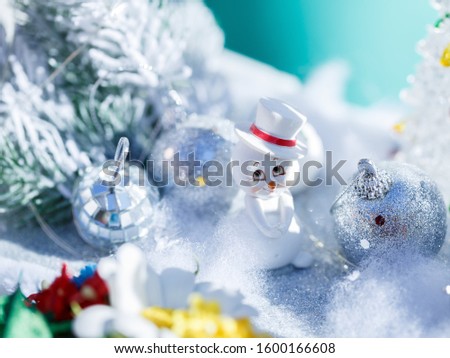 
snowman in white snow next to silver balls